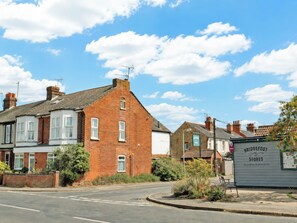 A street view with a row of houses, a road, and a sign for Bridgefoot Stores. - 3 bedroom accommodation in Reydon, Southwold (Reydon, Southwold)