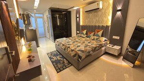 Quarto moderno com uma cama grande, mesas de cabeceira, ar condicionado e um espelho.