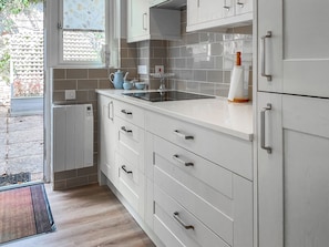 A modern kitchen with white cabinetry, a built-in oven, and a window with a view of the outside. - 2 bedroom accommodation in Devon, Sidmouth, Salcombe Regis, Budleigh Salterton, Seaton (Devon, Sidmouth, Salcombe Regis, Budleigh Salterton, Seaton)