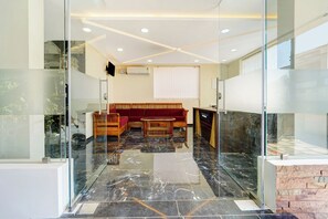 Ein modernes Interieur mit einer Sitzecke, einer Glastrennwand und einem Marmorboden.