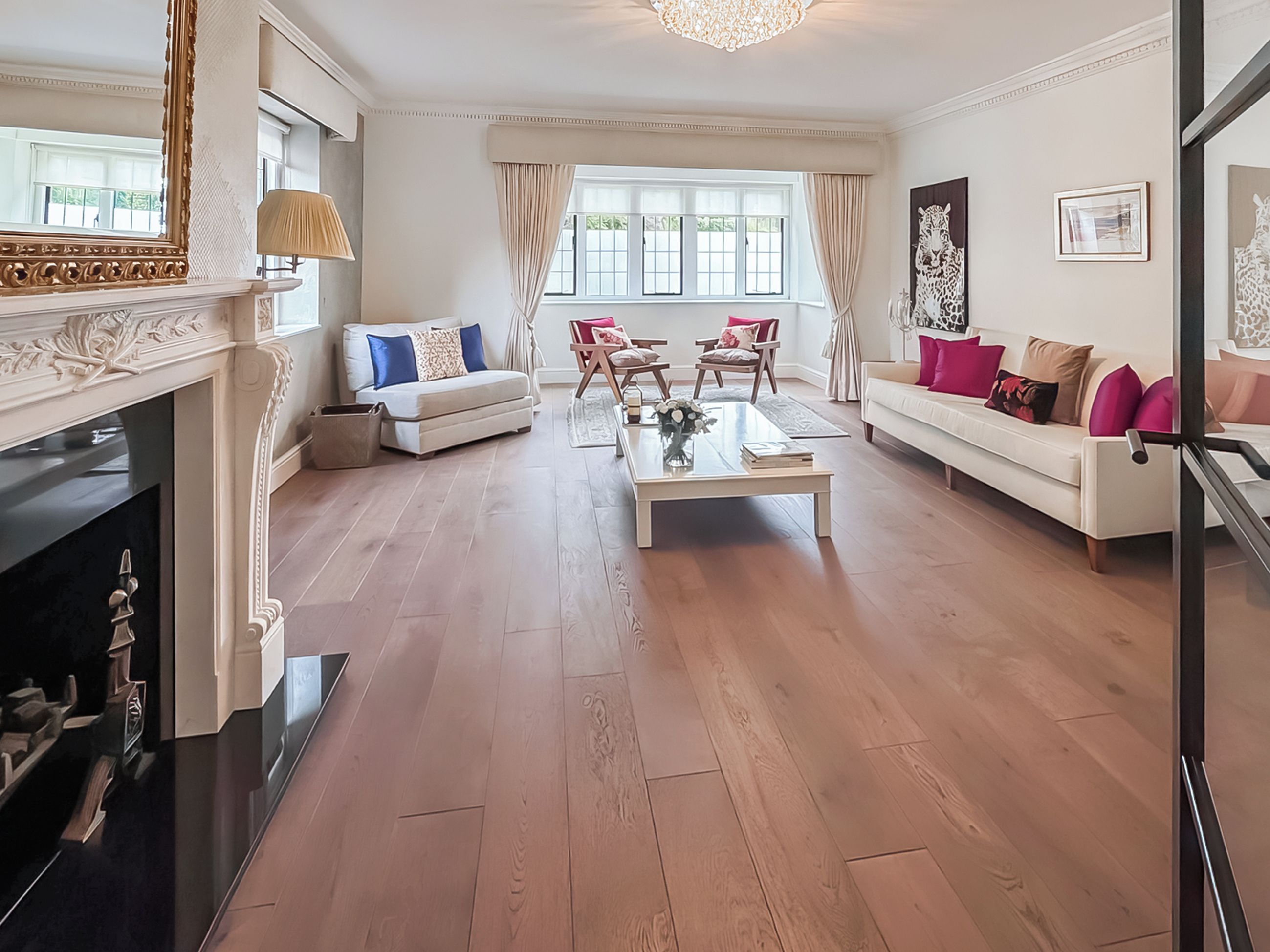 Un salon spacieux avec une cheminée, des canapés et une table basse.