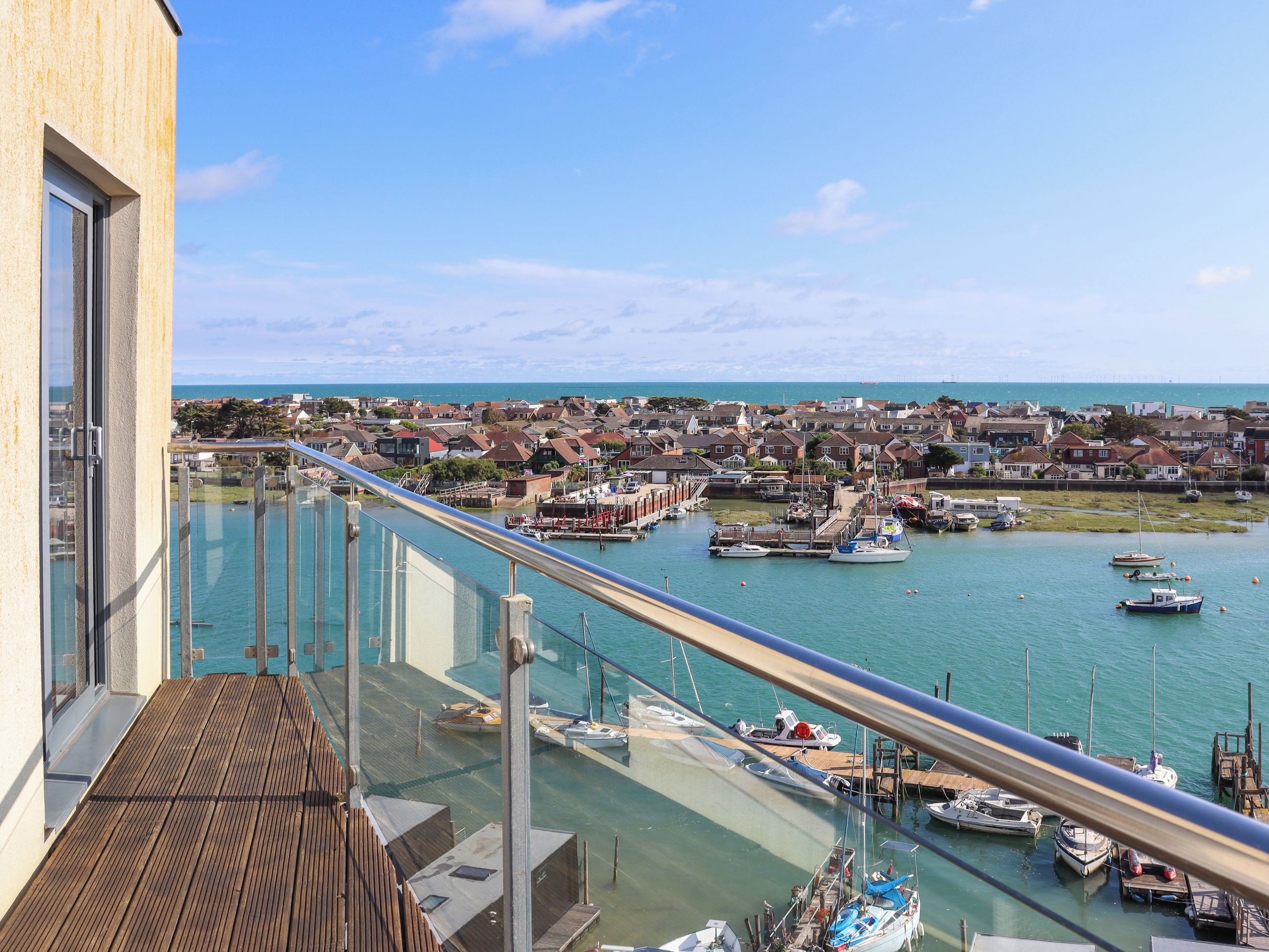 Un balcon avec vue sur un port de plaisance et sur la ville.