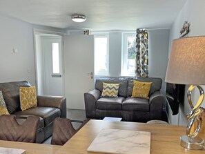 A living room with a sofa set, a coffee table, and a lamp. - 3 bedroom accommodation in Bude (Bude)