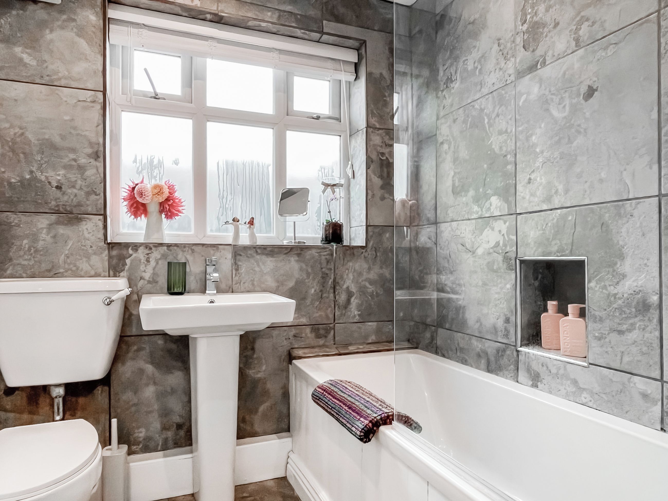 A bathroom with a toilet, sink, and bathtub.