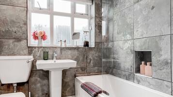A bathroom with a toilet, sink, and bathtub.