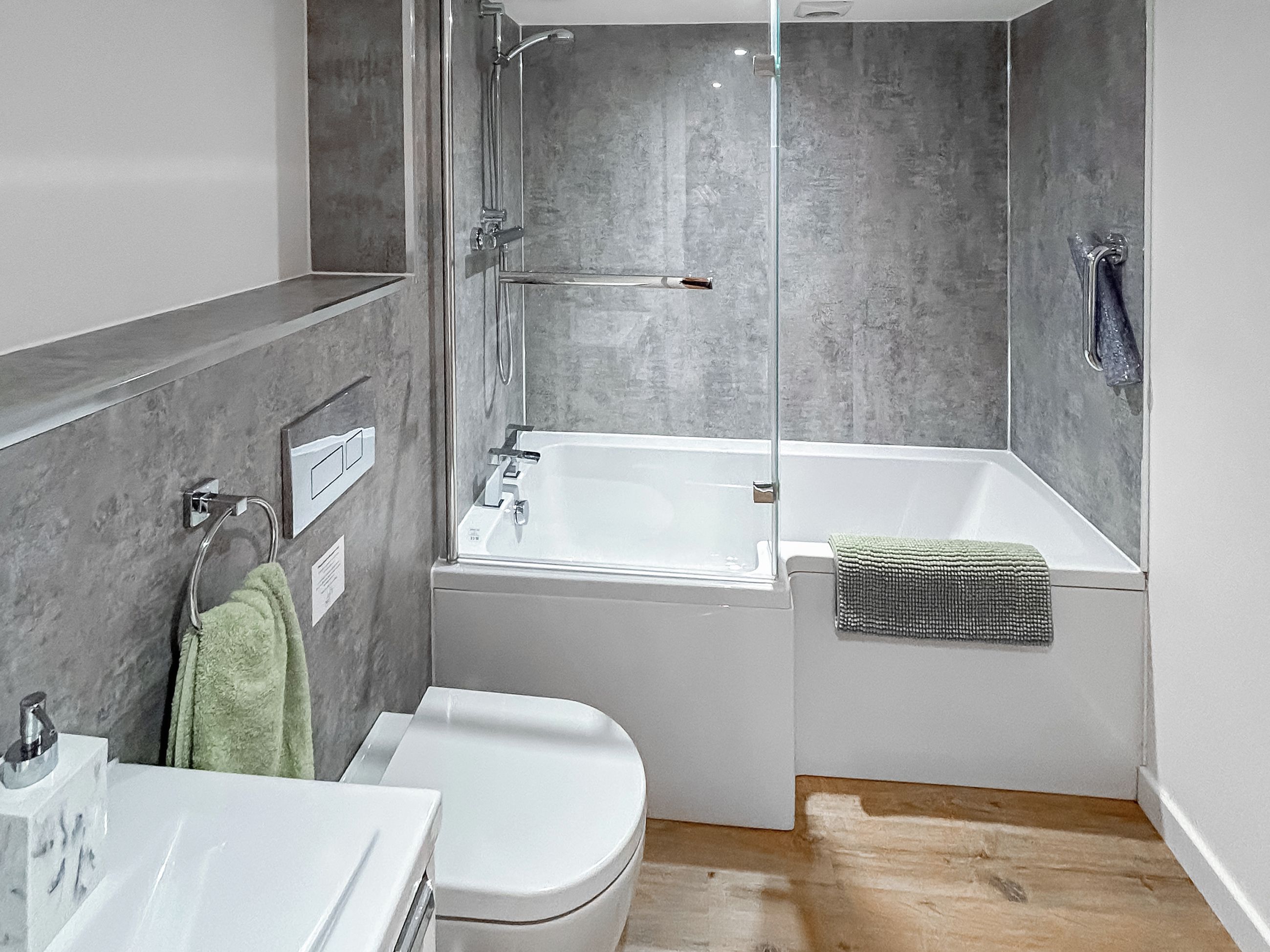 A modern bathroom with a bathtub, toilet, and sink.