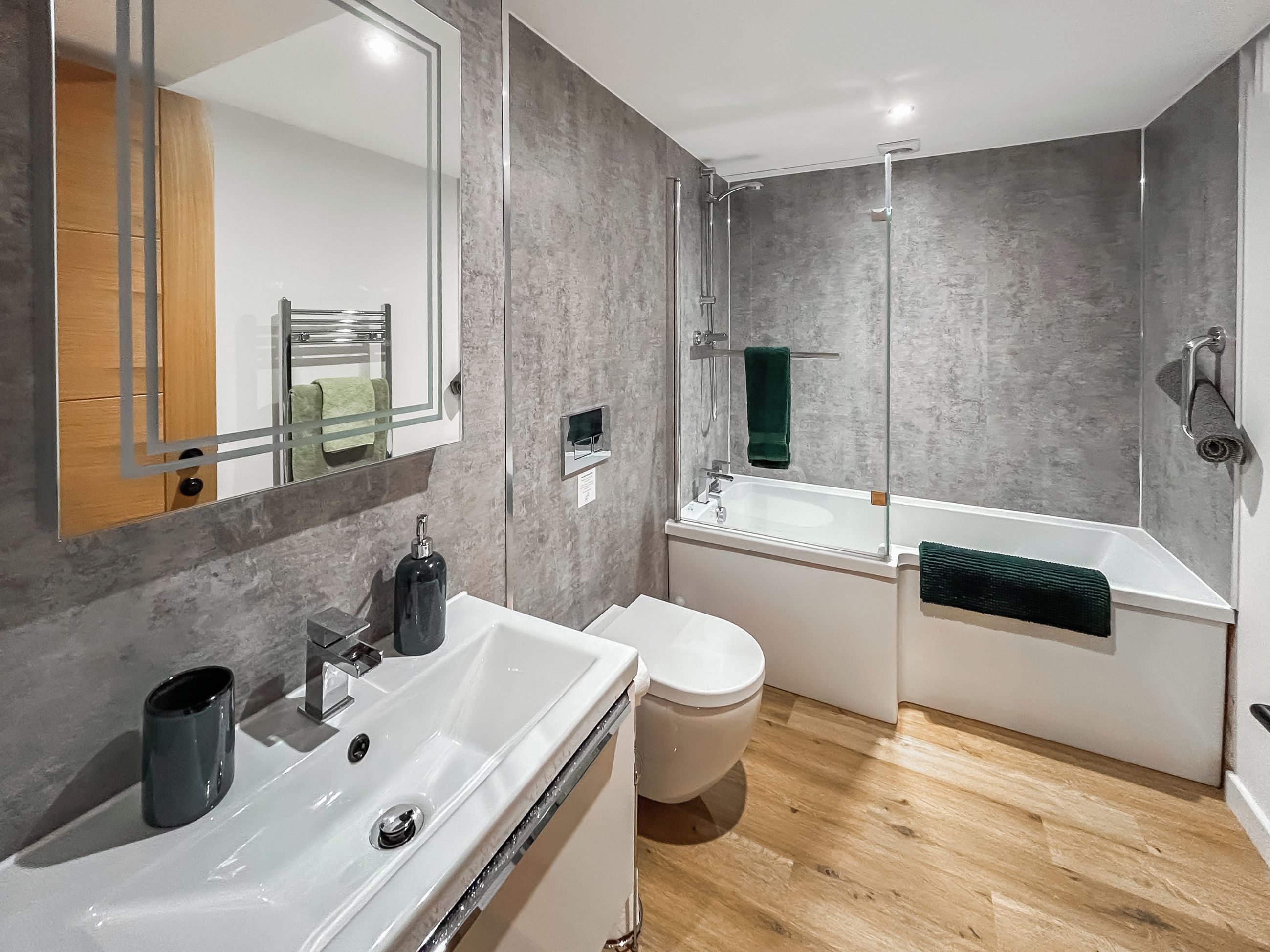 Une salle de bain moderne avec un lavabo blanc, des toilettes et une baignoire.
