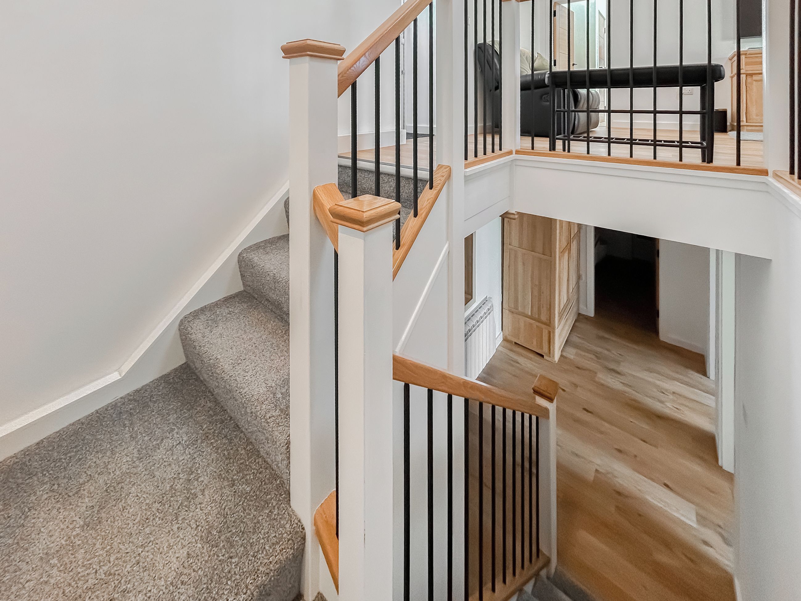 A staircase with wooden handrails and a carpeted landing.