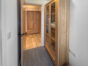A hallway with a wooden wardrobe and a carpeted floor.