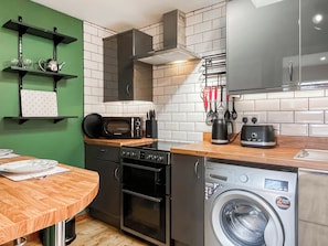 A compact kitchen with a microwave, toaster, and washing machine.