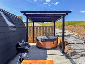 A covered outdoor area with a hot tub, a barbecue grill, and a wooden deck. - 1 bedroom accommodation in Wigglesworth (Wigglesworth)