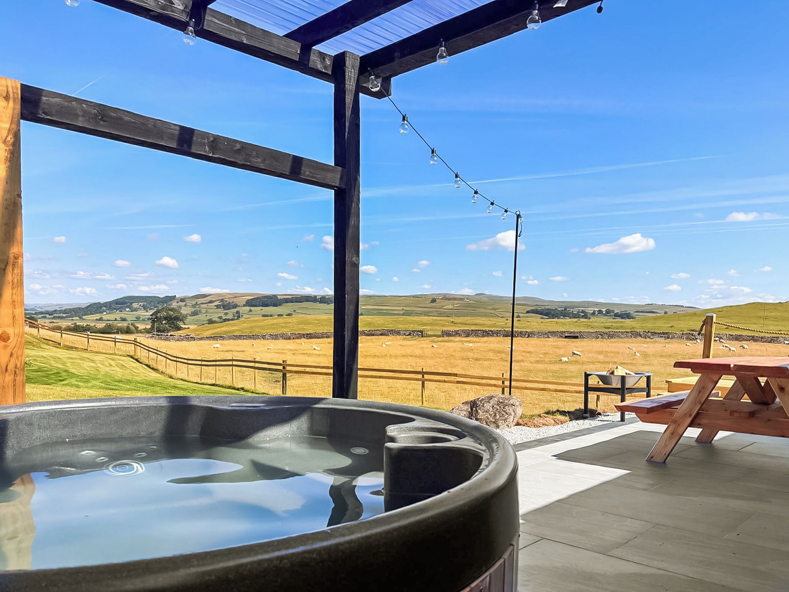 Ofurô em um terraço com vista para paisagem rural.