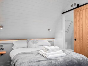 Ein Schlafzimmer mit Bett, Nachttisch, Schrank und Deckenleuchten.