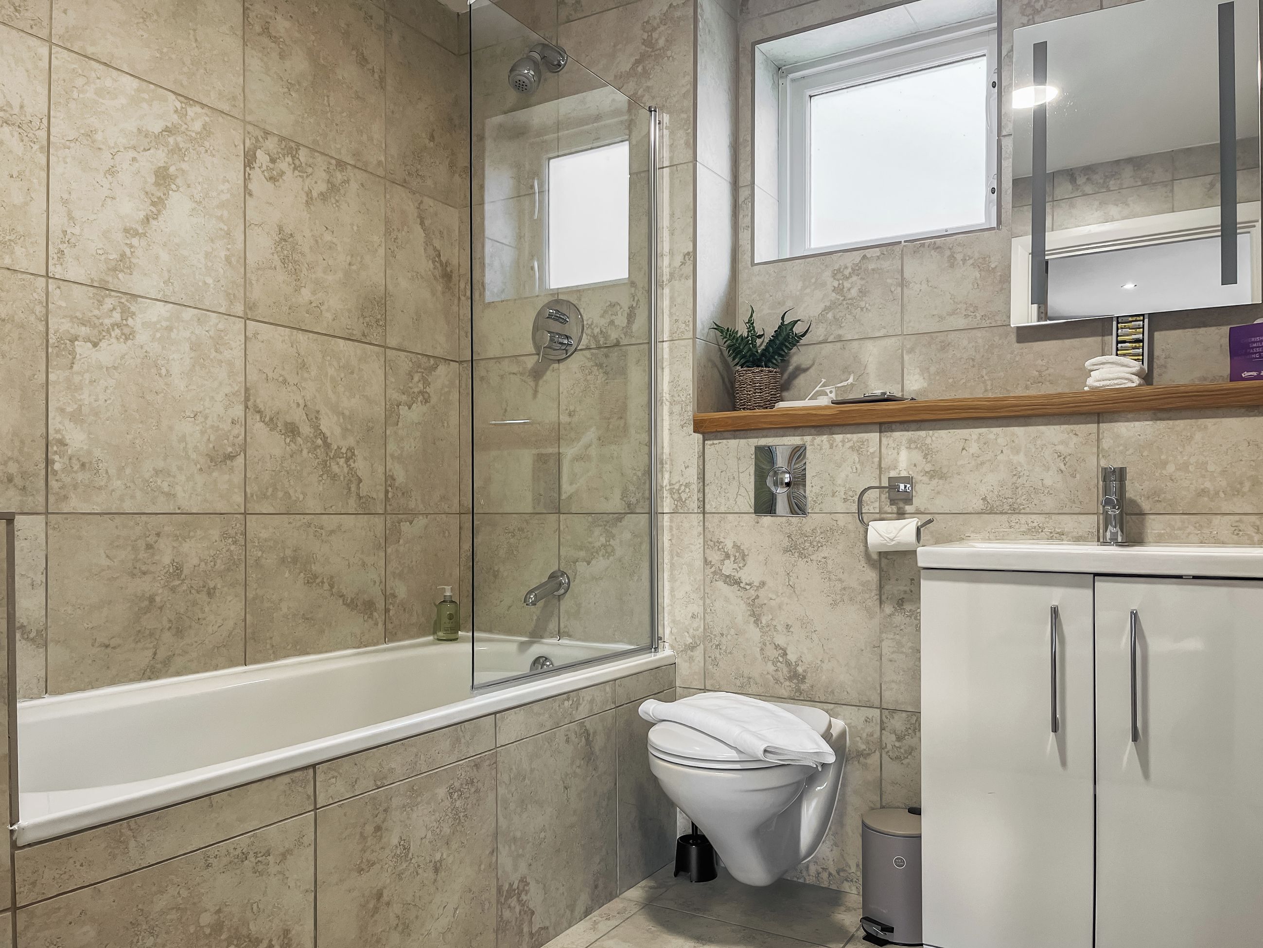A bathroom with a bathtub, toilet, and sink.