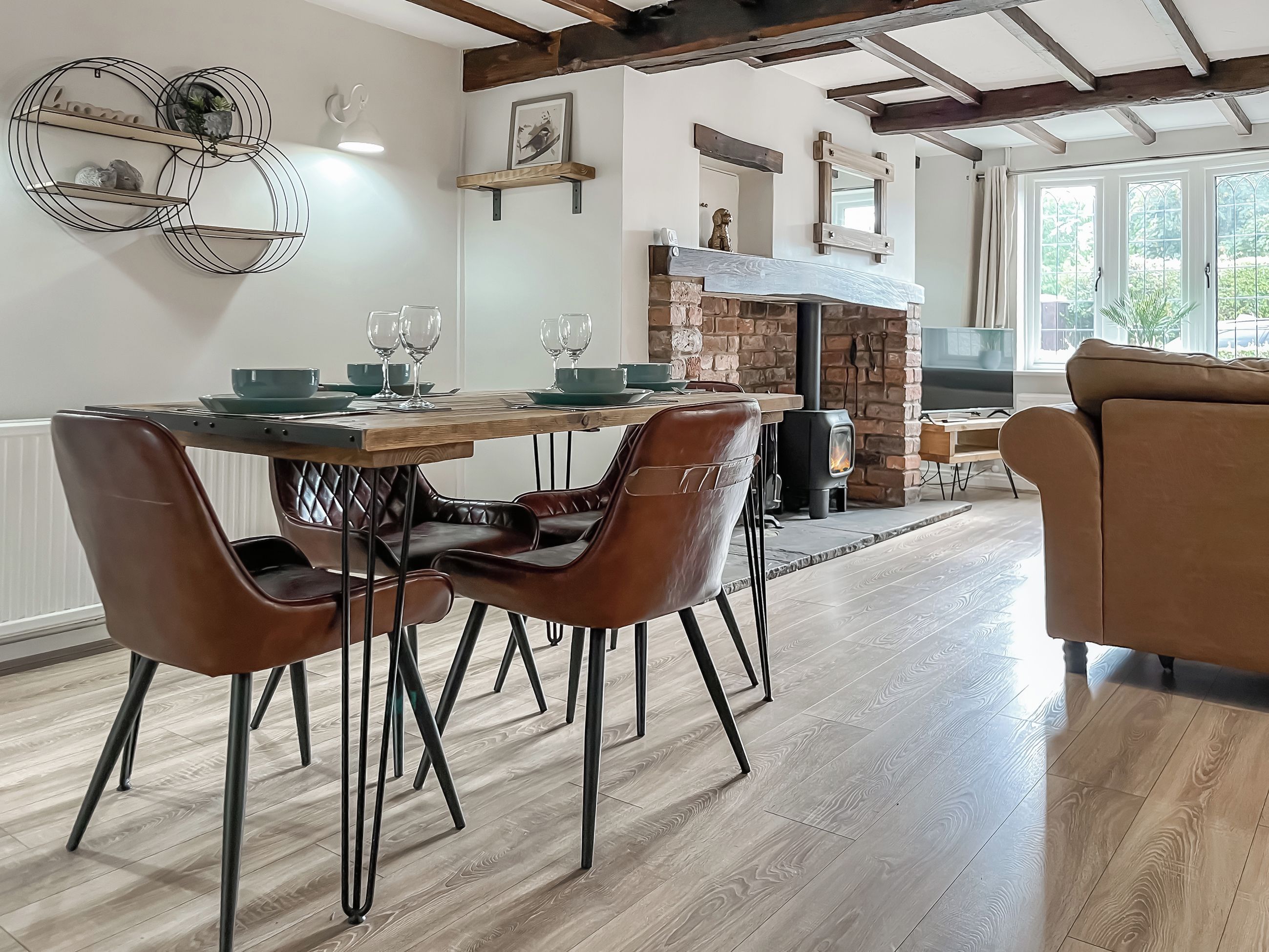 Un coin repas avec une table en bois, des chaises en cuir et une cheminée en pierre.