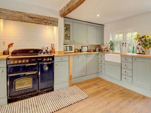 A kitchen with a vintage stove, light blue cabinets, and a wooden countertop. - 4 bedroom accommodation in Shirrell Heath (Shirrell Heath)
