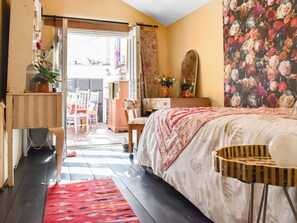 A bedroom with a bed, a desk, a chair, a dresser, and a mirror. - 4 bedroom accommodation in Horsham Saint Faith (Horsham Saint Faith)