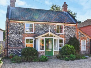 A house with a stone facade, a green door, and a small porch. - 4 bedroom accommodation in Horsham Saint Faith (Horsham Saint Faith)