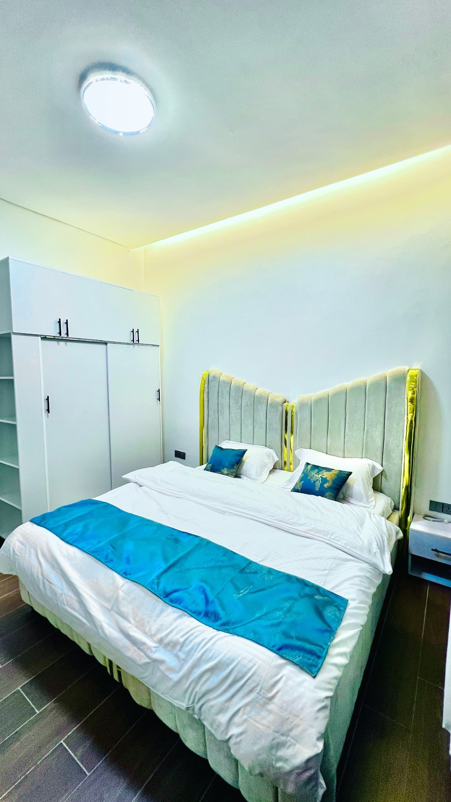 Quarto com cama, guarda-roupa e mesa de cabeceira.