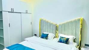 Een slaapkamer met een bed, een kledingkast en een nachtkastje.