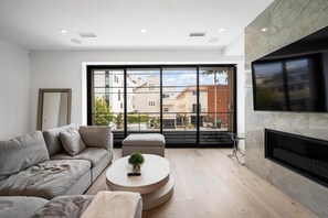 Ein modernes Wohnzimmer mit einer Couch, einem runden Couchtisch und einem Kamin.