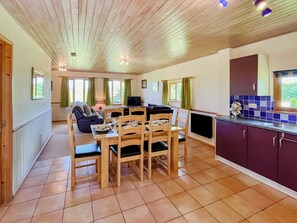 A cozy room with a dining table, chairs, a sofa, and a TV. - Hardy Chalet - UK47157 (West Stour, near Gillingham)