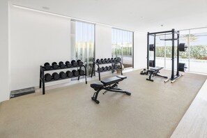 A gym with weightlifting equipment, dumbbells, and benches. - Muraba Dia | Ultra-Luxe Sea View Residence (Dubai)
