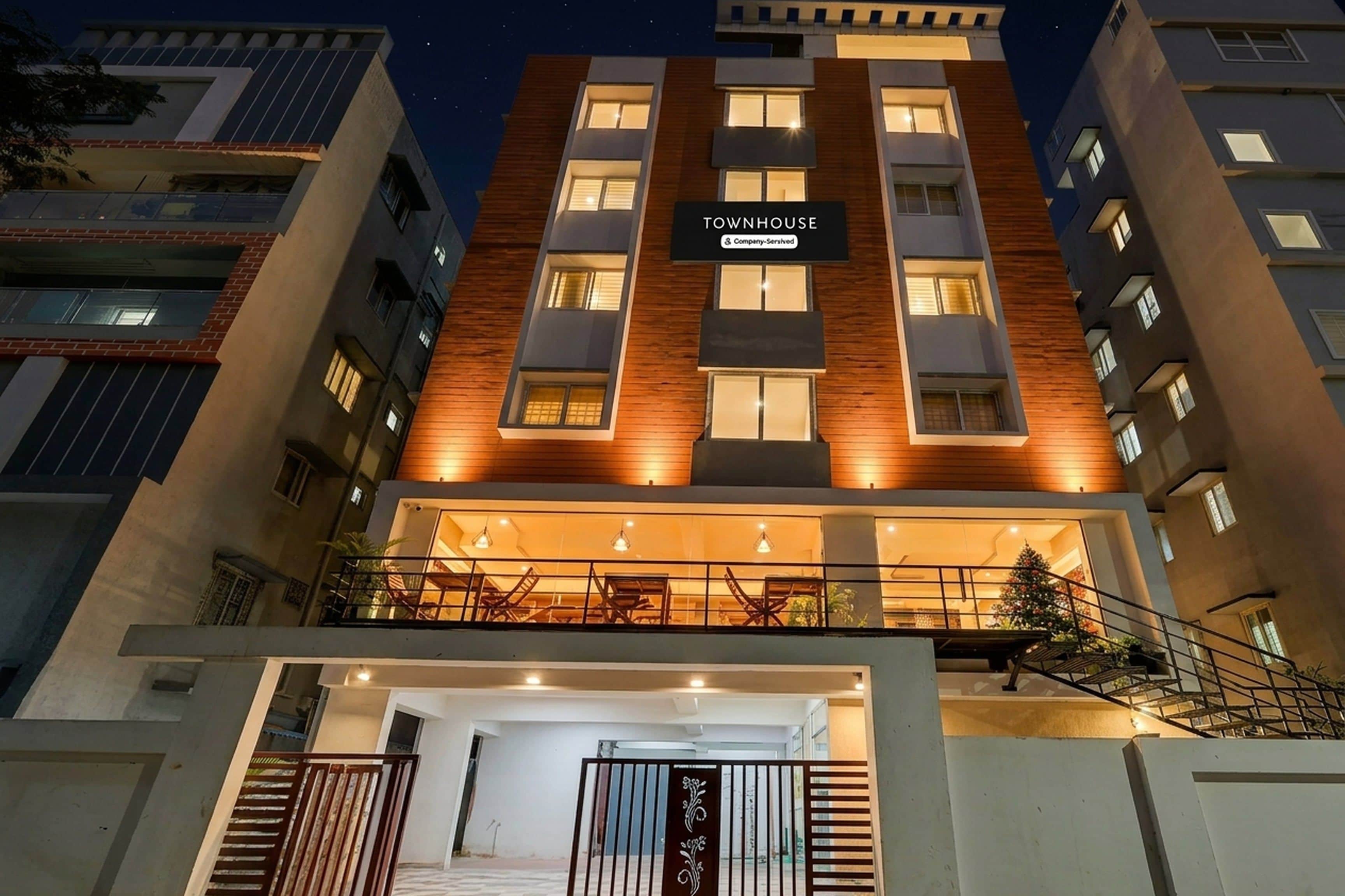 A multi-story building with a sign reading 'TOWNHOUSE' and 'Company-Serviced.'