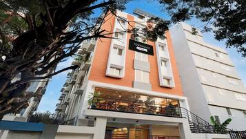 Un edificio de varios pisos con un cartel que indica 'TOWNHOUSE' y 'Company-Serviced'.