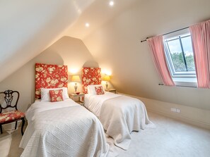 A bedroom with two beds, a window with curtains, and a chair. - 2 bedroom accommodation in Knole, near Langport (Knole, near Langport)