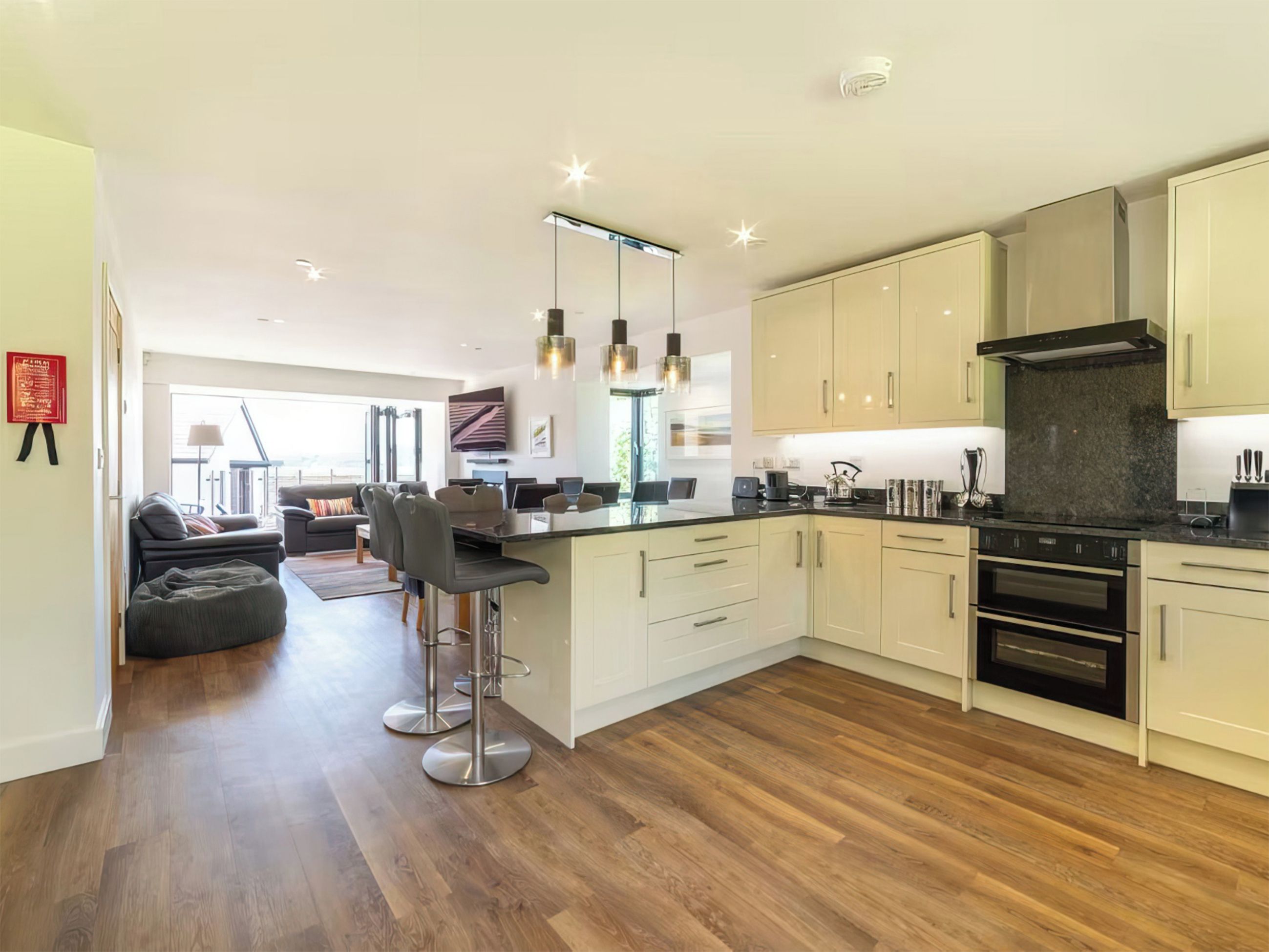 A modern kitchen with a central island, stainless steel appliances, and pendant lighting.