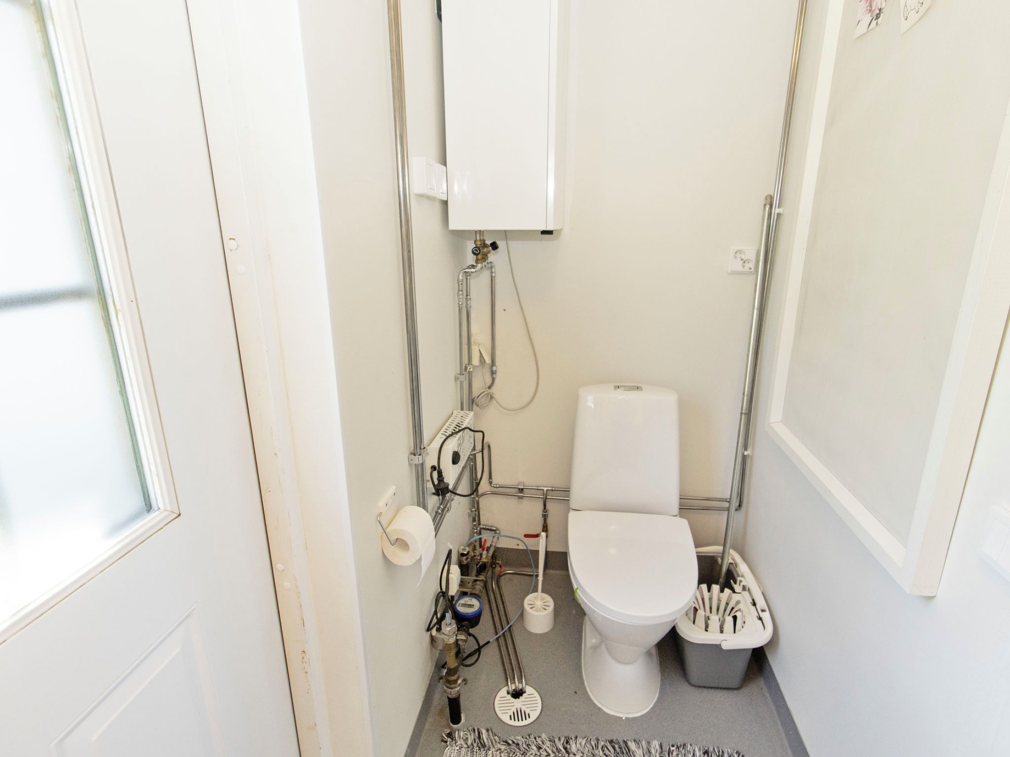 A compact bathroom with a toilet, a bidet, and a hand dryer.