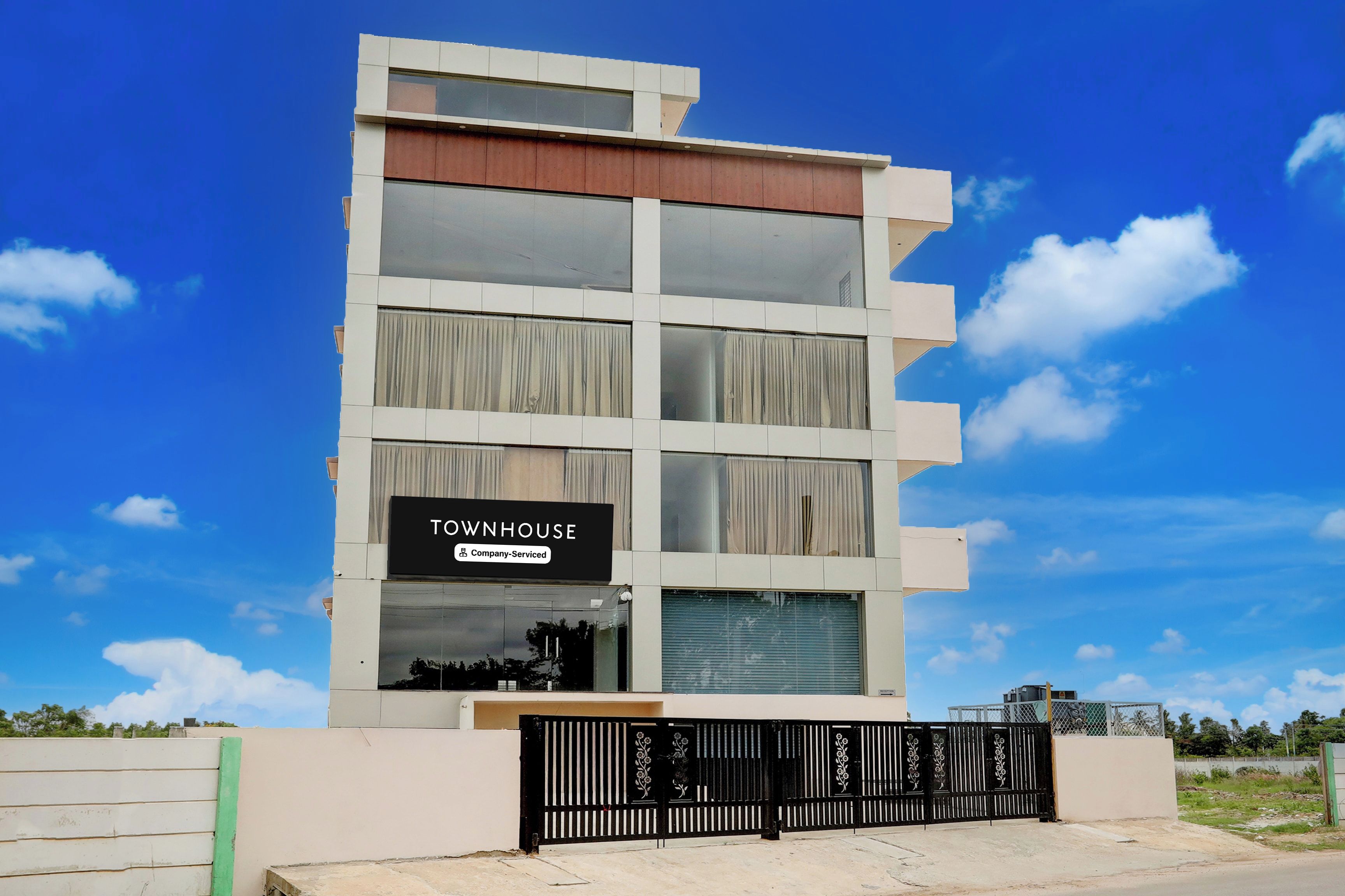 A multi-story building with a sign indicating it is a company-serviced townhouse.