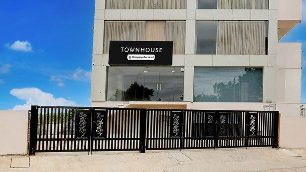 Un edificio de varios pisos con un letrero que dice 'TOWNHOUSE Company-Serviced'.