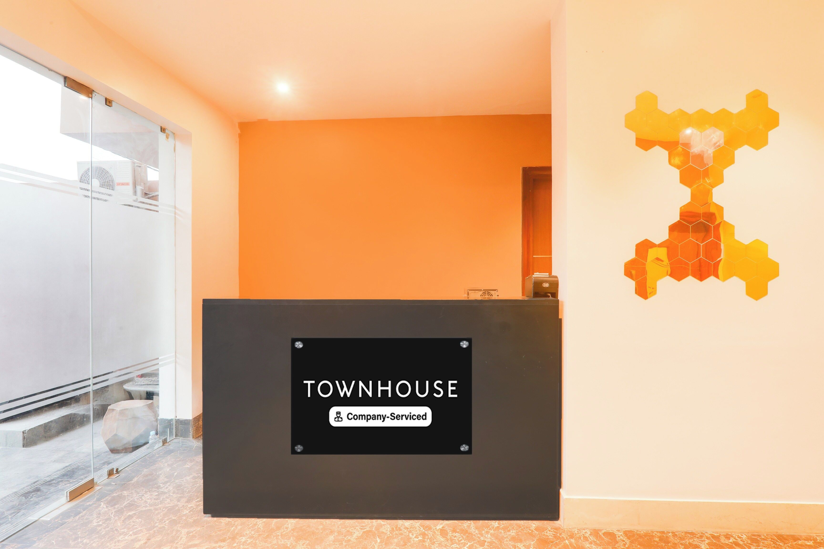 Una recepción con un cartel que indica 'TOWNHOUSE Company-Serviced'.