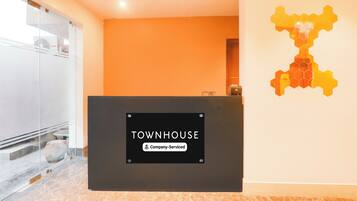 Una recepción con un cartel que indica 'TOWNHOUSE Company-Serviced'.