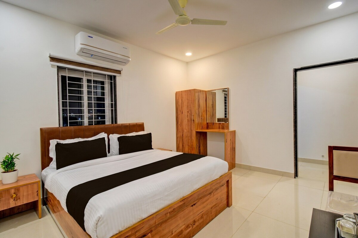 Un dormitorio con cama, mesita de noche, aire acondicionado, ventana, ventilador de techo y espejo.