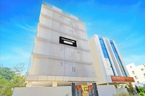 A modern building with a sign indicating it is a company-serviced townhouse. - Townhouse Oak Suchitra Kompally Road (Hyderabad)