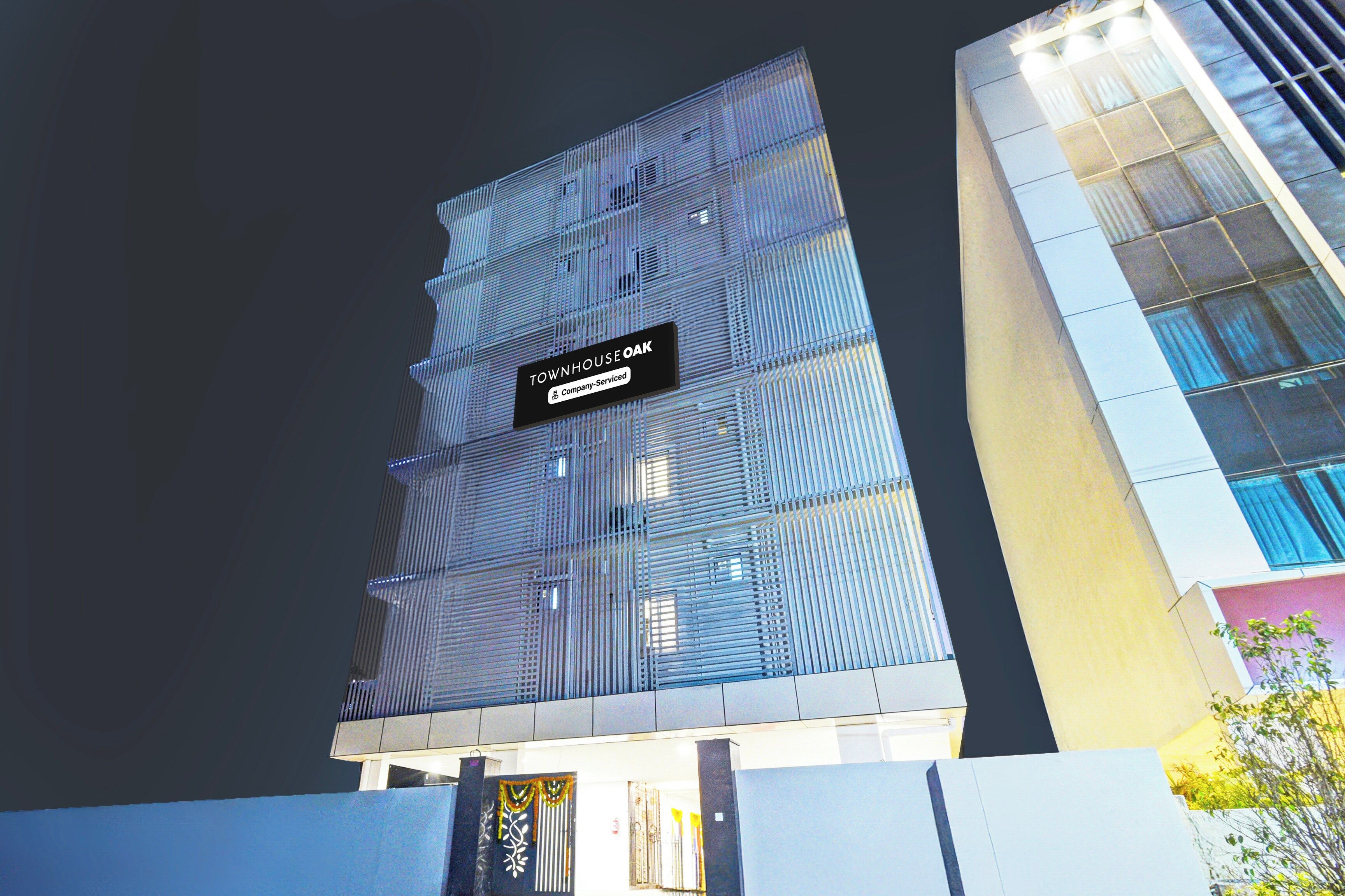 Un edificio moderno con un letrero que dice 'TOWNHOUSE OAK' y un logotipo de la empresa.