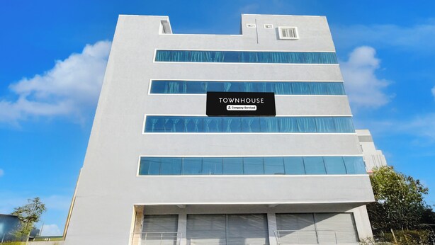 A modern building with a sign that reads 'TOWNHOUSE Company Serviced'.