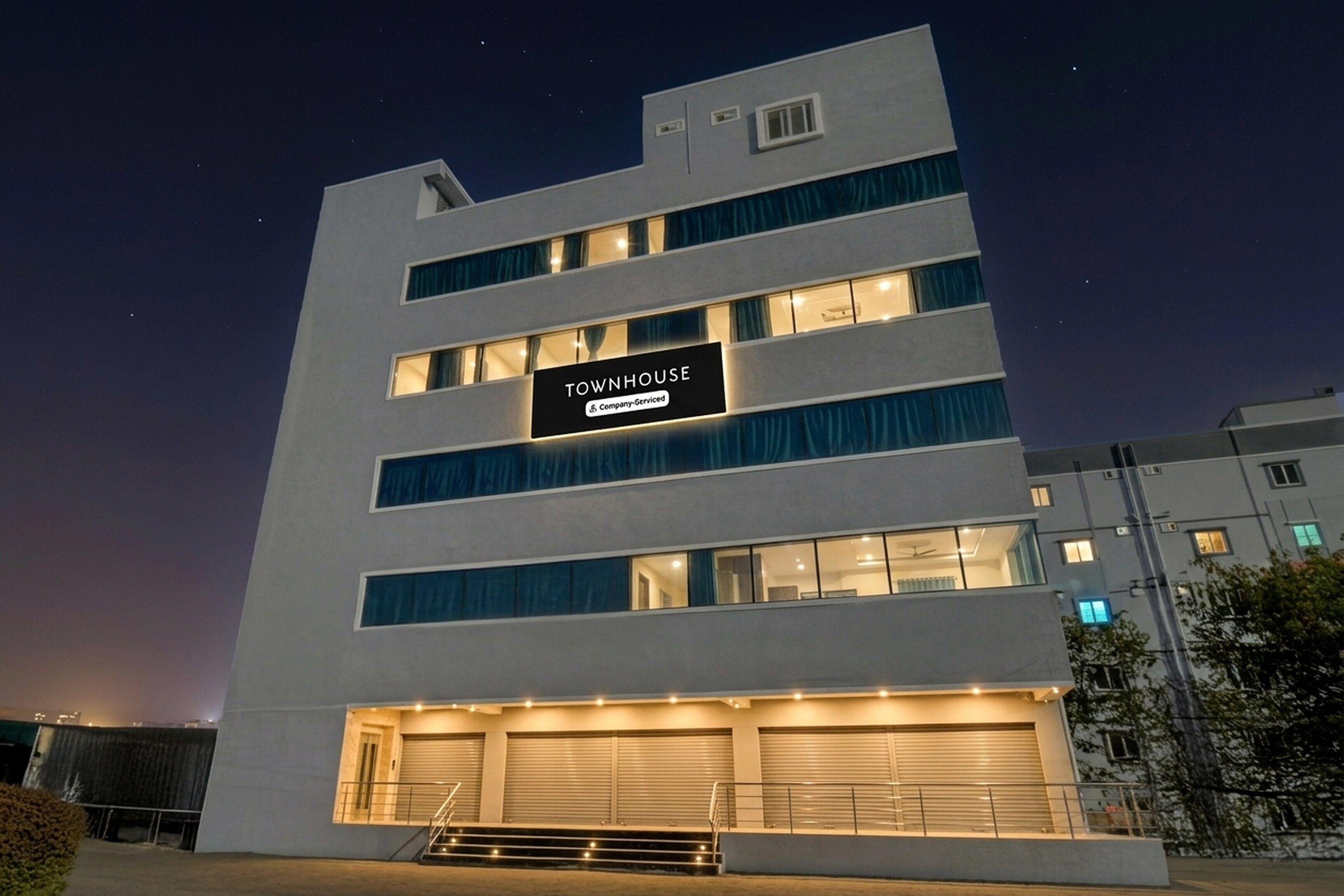 A multi-story building with a sign reading 'TOWNHOUSE' and a company-serviced label.