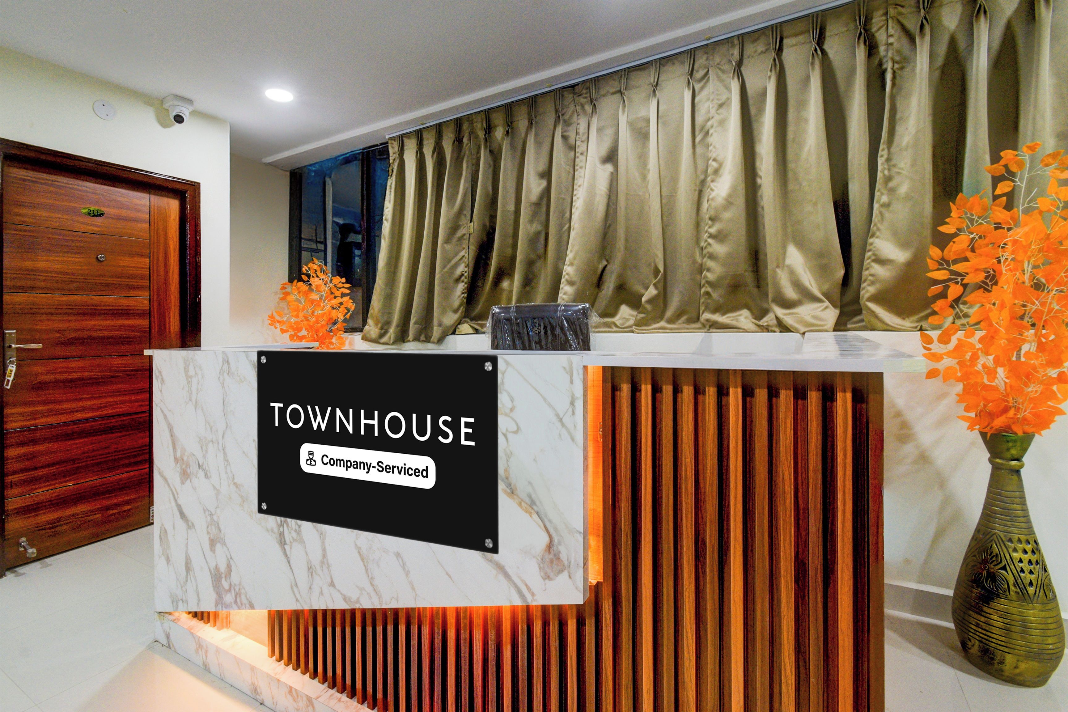Una mesa de recepción con un cartel que dice 'TOWNHOUSE Company Serviced'.