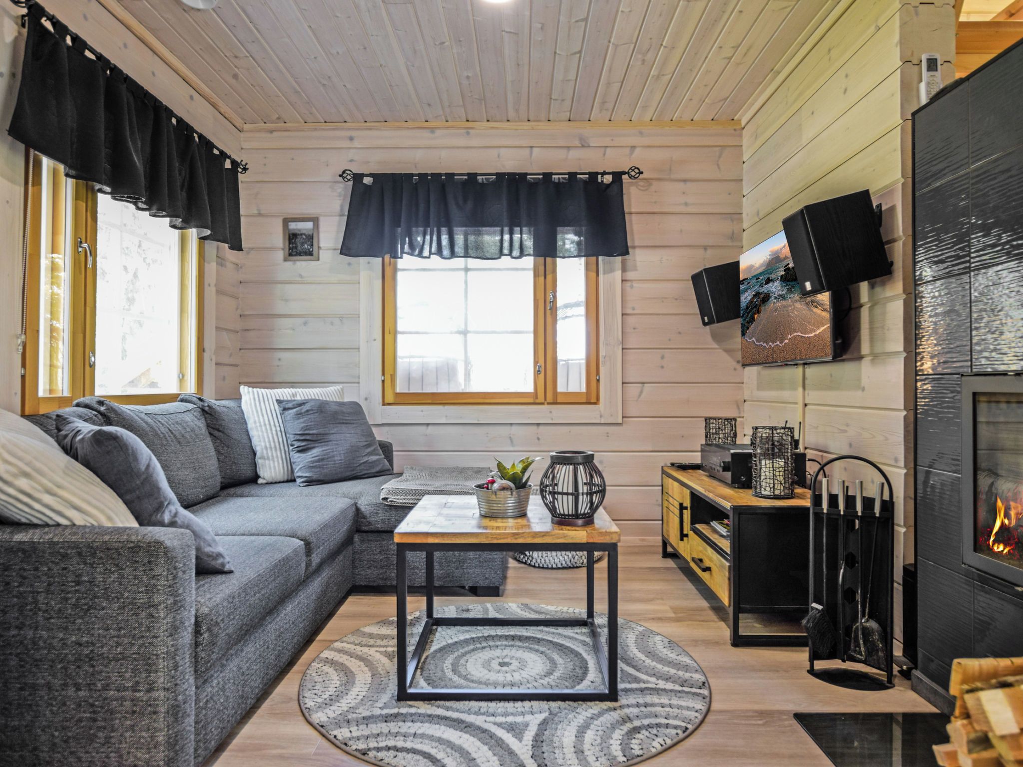 Una sala acogedora con un sofá gris, una mesita de centro y una chimenea.