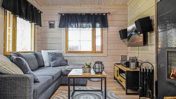 Una sala acogedora con un sofá gris, una mesita de centro y una chimenea.