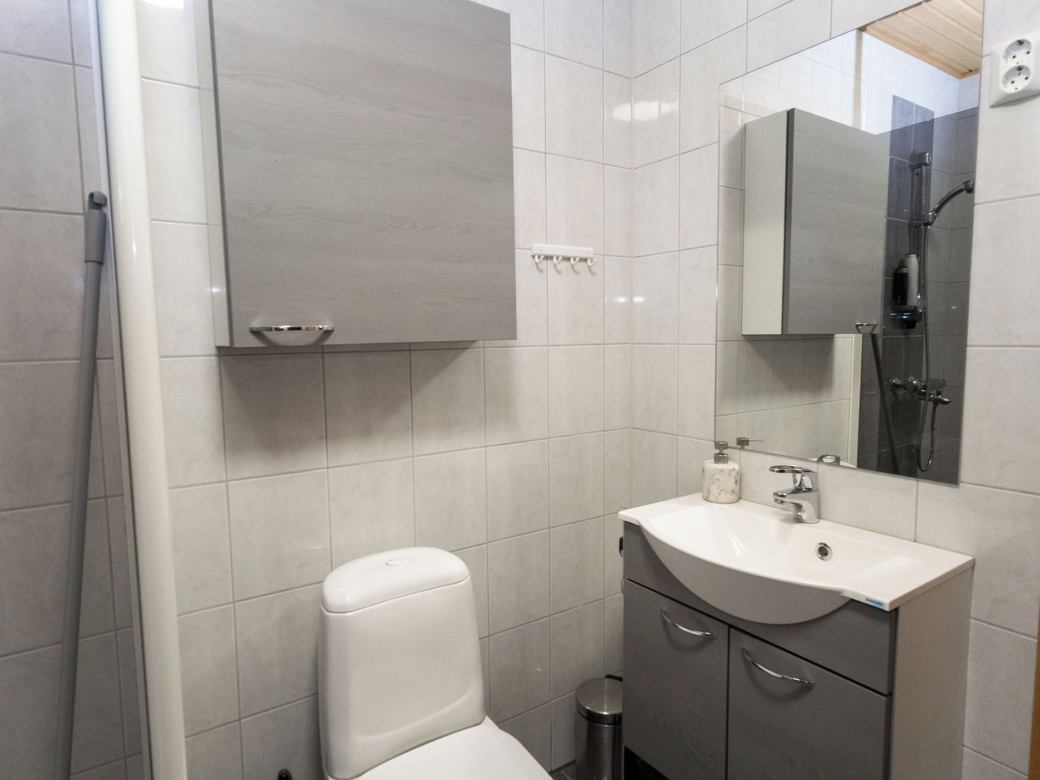 Um banheiro moderno com vaso sanitário, pia, bancada e área de chuveiro.