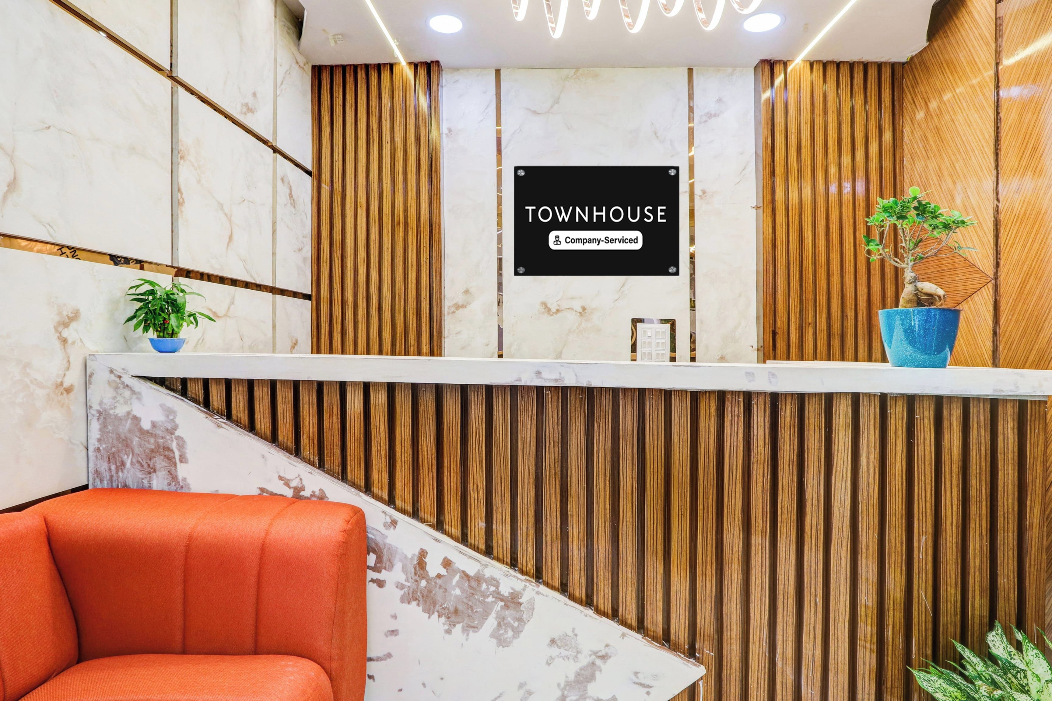 A reception desk with a sign that reads 'TOWNHOUSE Company-Serviced.'