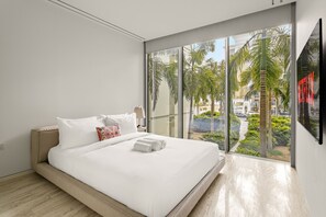 A modern hotel room with a large bed, a view of palm trees, and a balcony. - Muraba Residences - 103-n 2BD (Dubai)