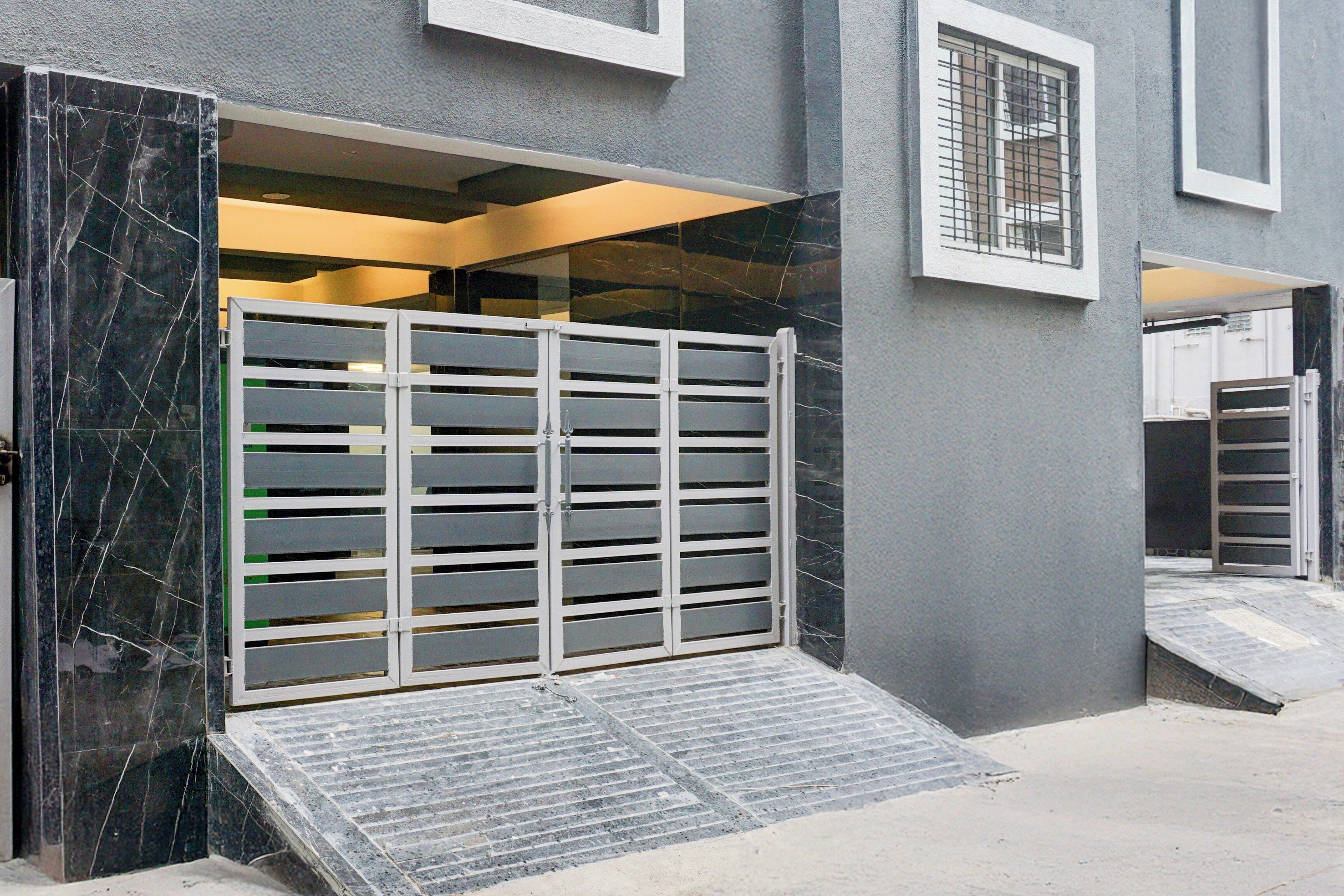 Una entrada con acceso restringido y una rampa que conduce a la entrada del edificio.