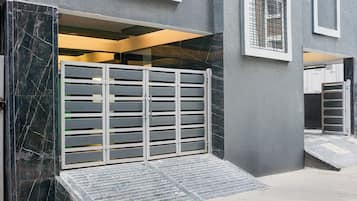 Una entrada con acceso restringido y una rampa que conduce a la entrada del edificio.