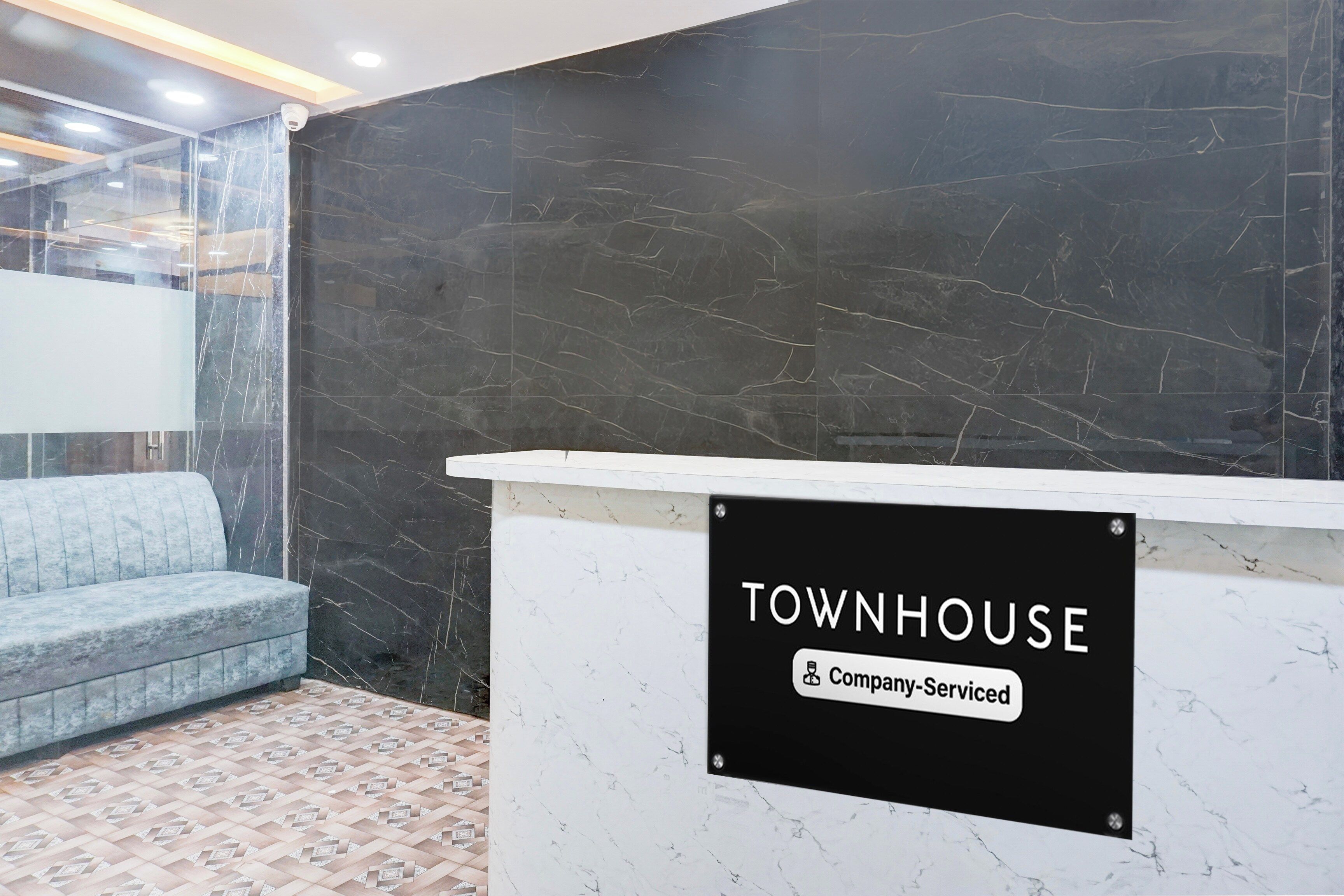 A reception desk with a sign that reads 'TOWNHOUSE Company Serviced'.